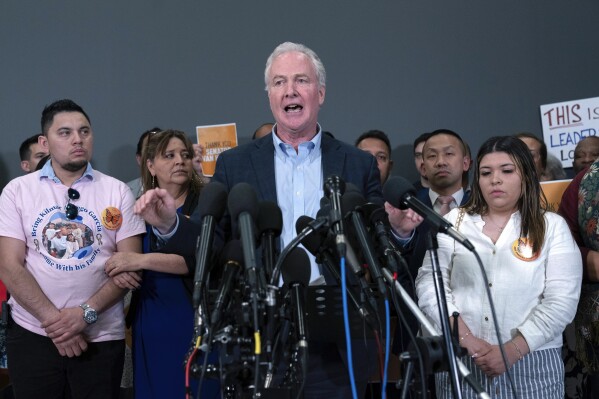 Sen. Chris Van Hollen, D-Md., center, accompanied by Cesar Abrego Garcia, from left, Cecilia Garcia and Jennifer Vasquez Sura, speaks during a news conference upon his arrival from meeting with Kilmar Abrego Garcia in El Salvador, at Washington Dulles International Airport, in Chantilly, Va., Friday, April 18, 2025. (AP Photo/Jose Luis Magana)